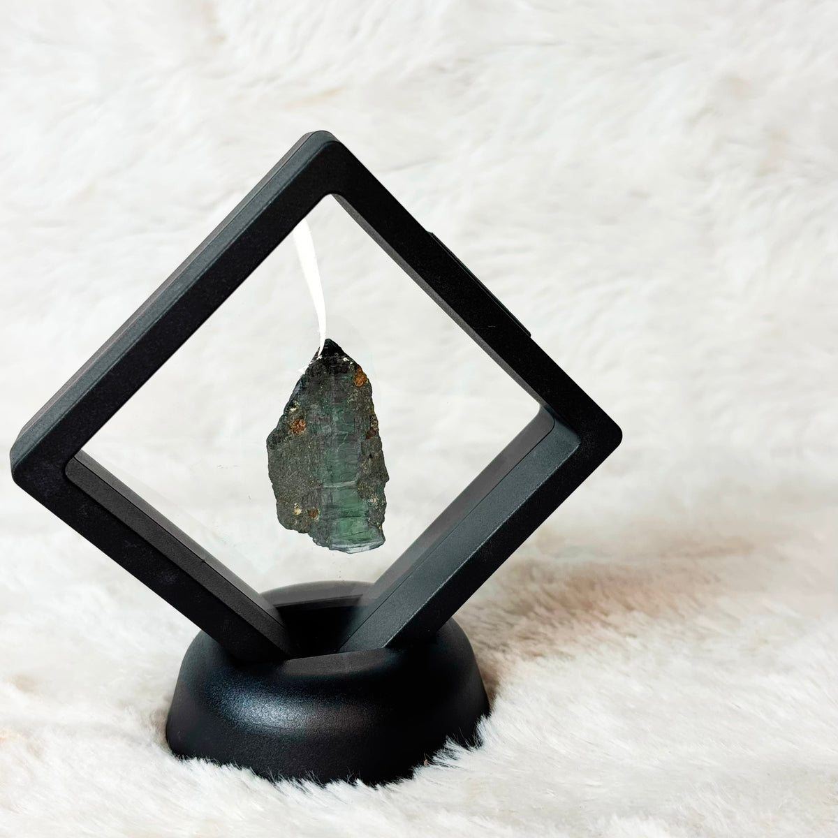 Framed Vivianite specimen on a white background