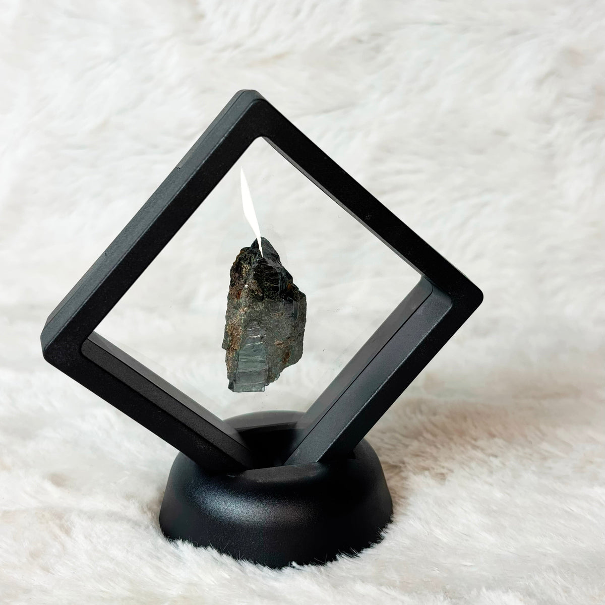 Framed Vivianite specimen on a white background