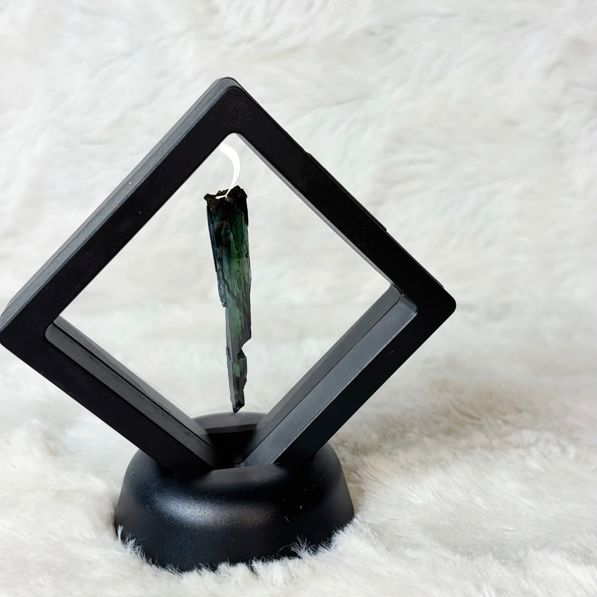 Framed Vivianite specimen on a white background