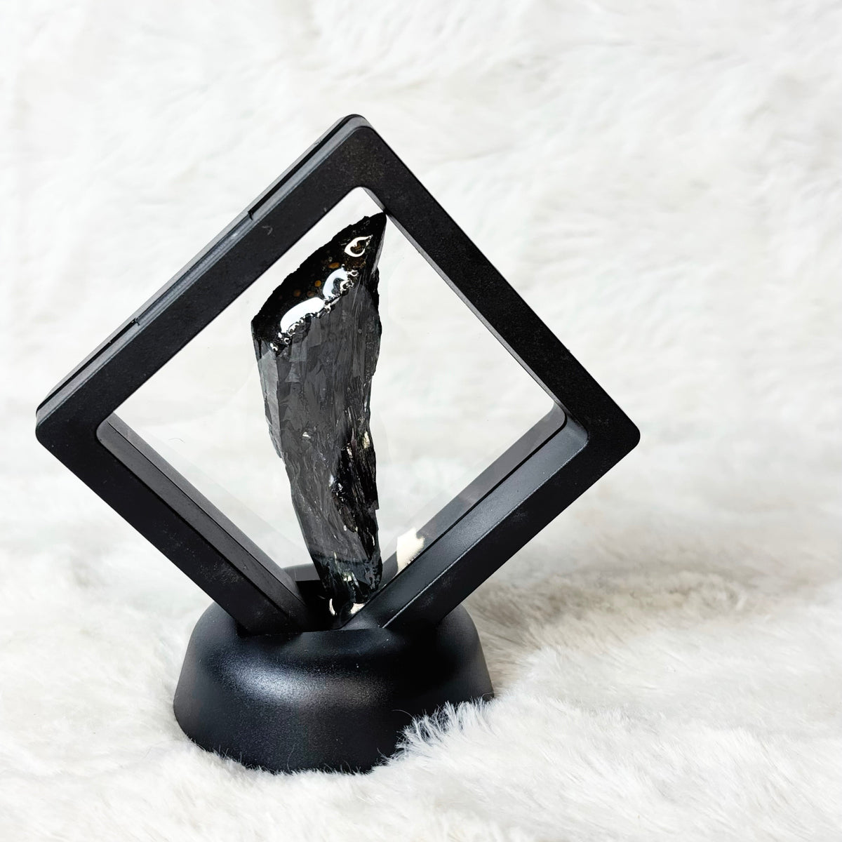 Framed Vivianite specimen on a white background