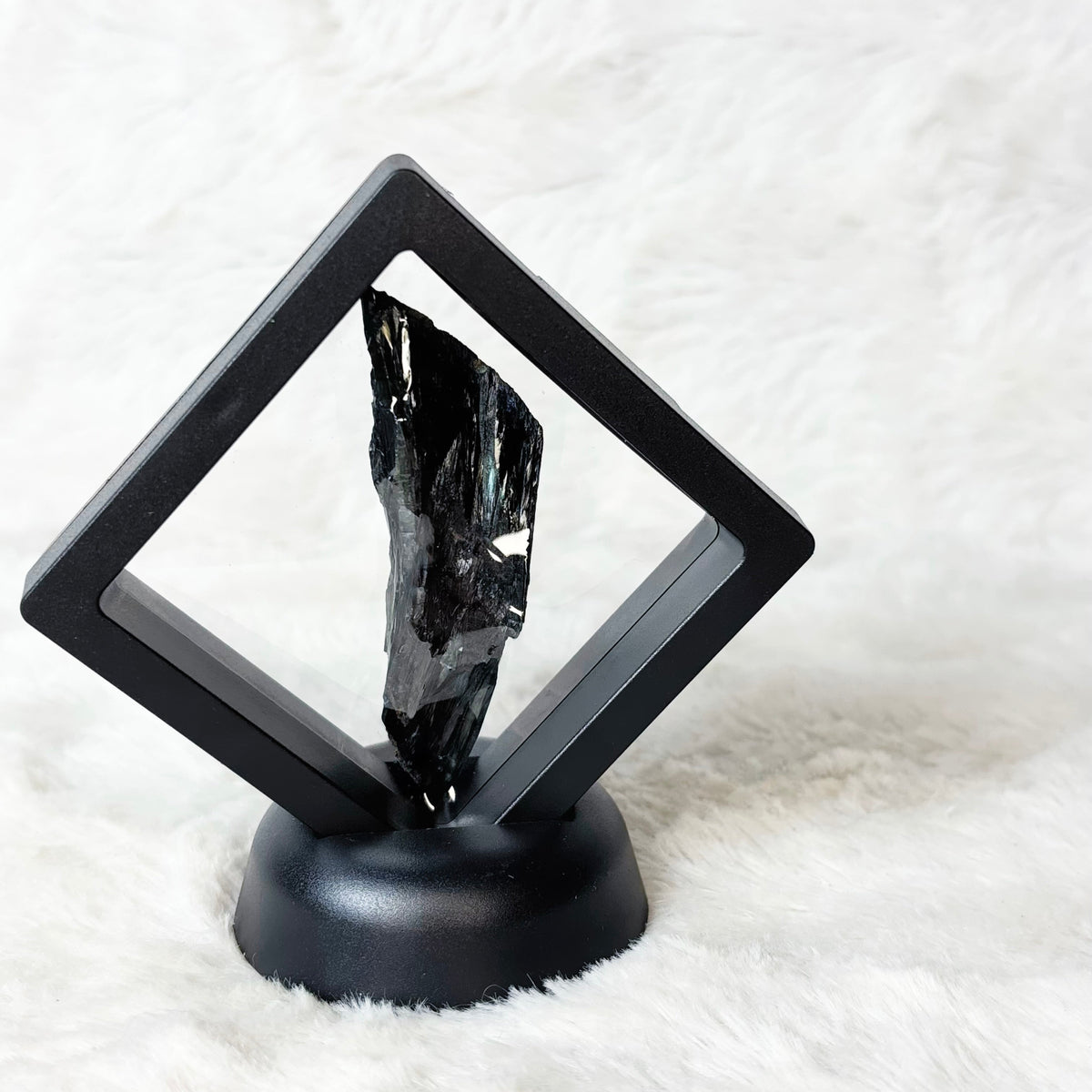 Framed Vivianite specimen on a white background