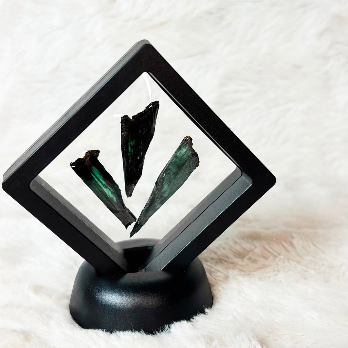 Three framed Vivianite specimens on a white background