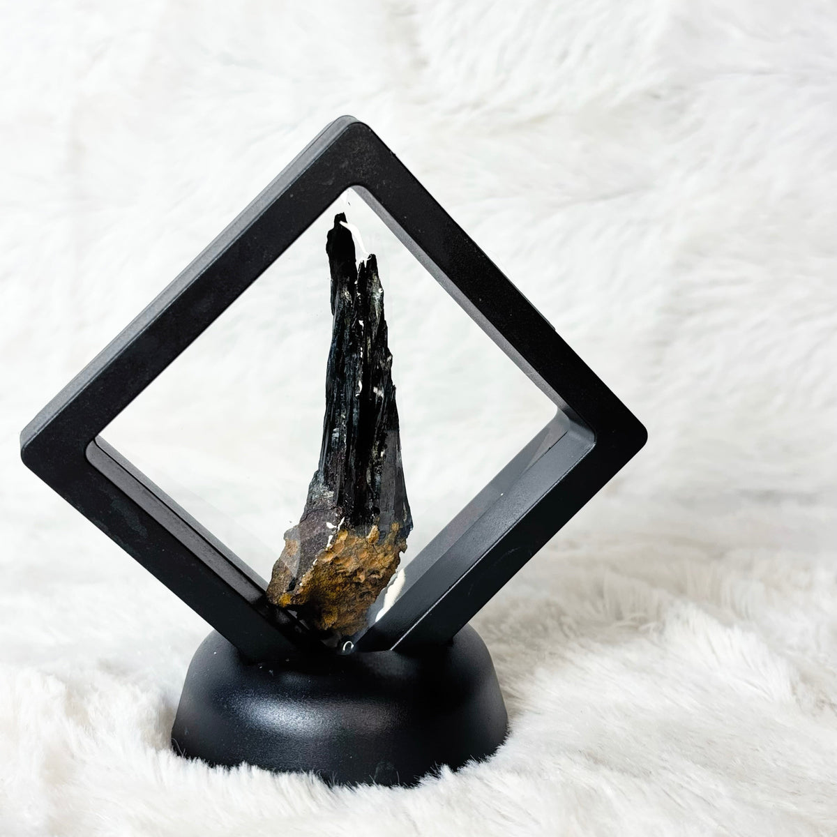 Framed Vivianite specimen on a white background