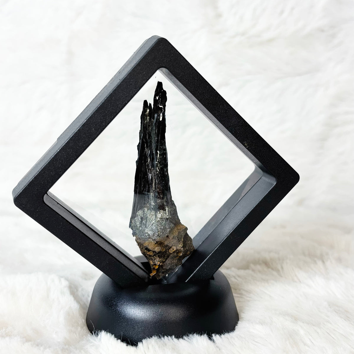 Framed Vivianite specimen on a white background