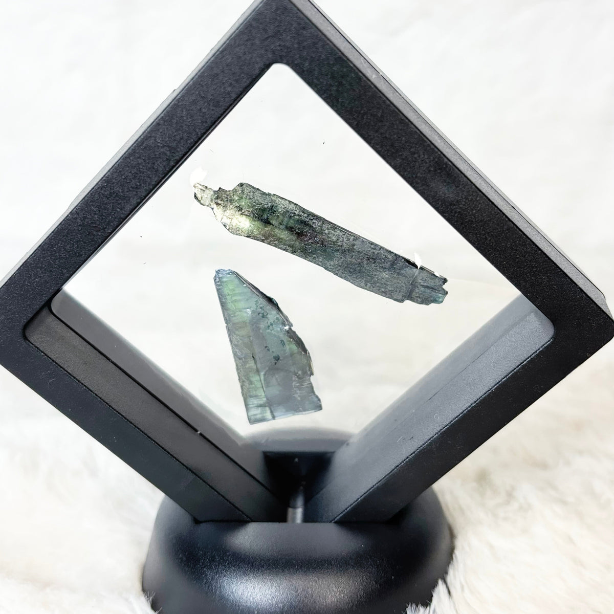 Framed Vivianite specimens on a white background