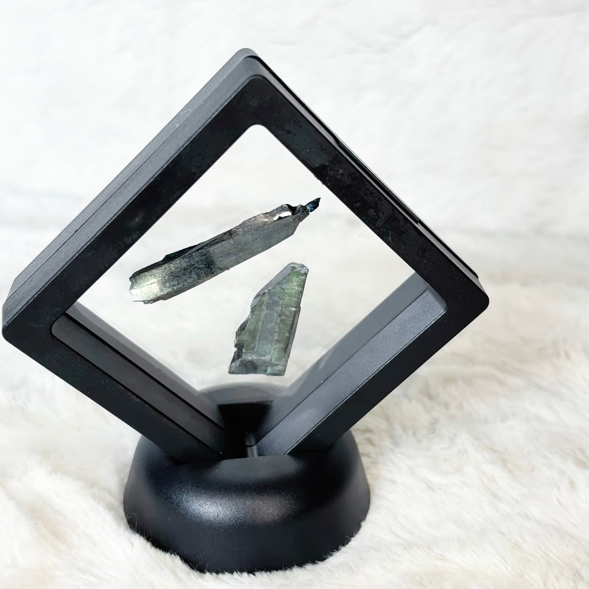 Framed Vivianite specimens on a white background