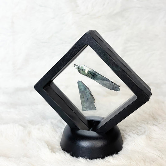 Framed Vivianite specimens on a white background