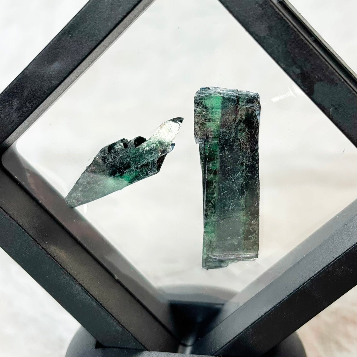 Framed Vivianite specimens on a white background